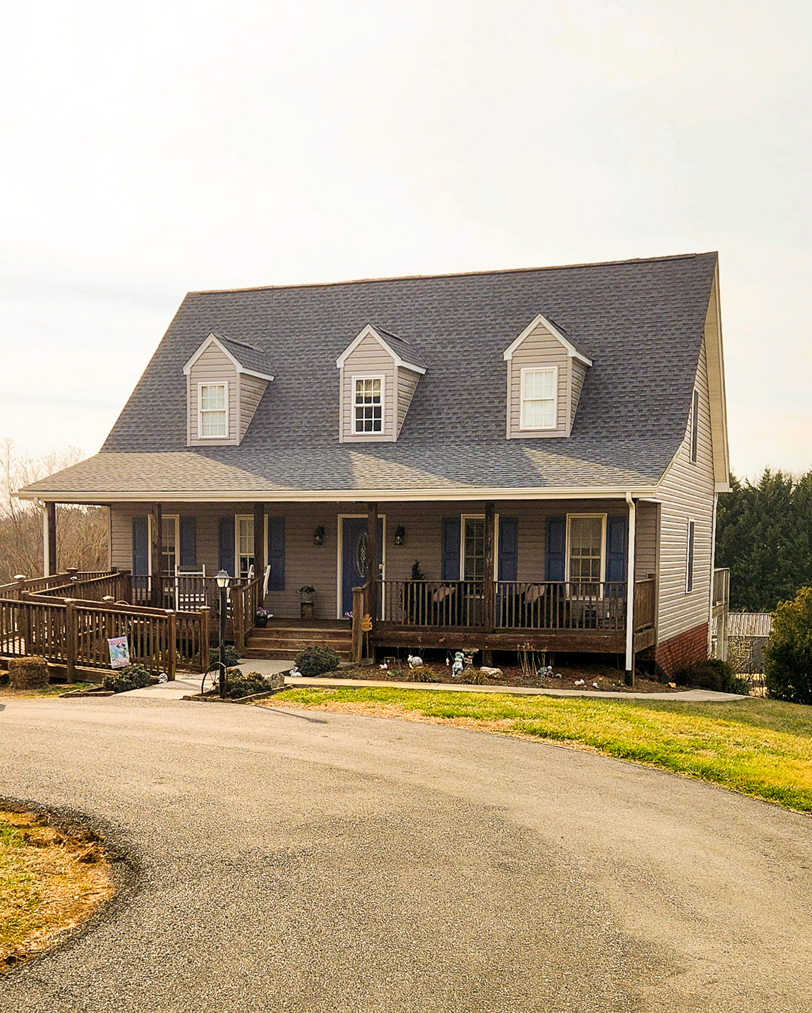A two-story house with a wide front porch, three dormer windows, and a curved driveway leading to the entrance belonging to Sponsored Residential Providers Karen & Matt Doyle in Bedford, Virginia.