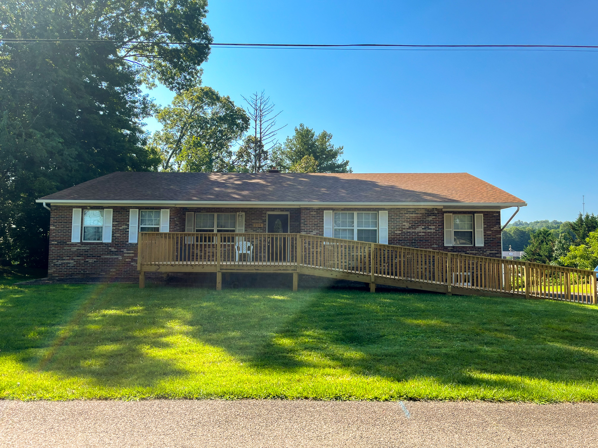 Single‑story brick house with a wooden accessibility ramp across the front lawn belonging to Sponsored Residential Providers Penny Day and Steven Coleman in Hillsville, Virginia.