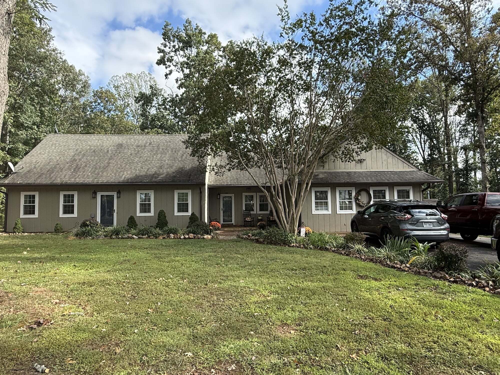 Wide, single-story home with a sloped roof, trees in the front yard, and several cars parked in the driveway belonging to Group Home Providers Melanie and Robert Jennings in Concord, Virginia